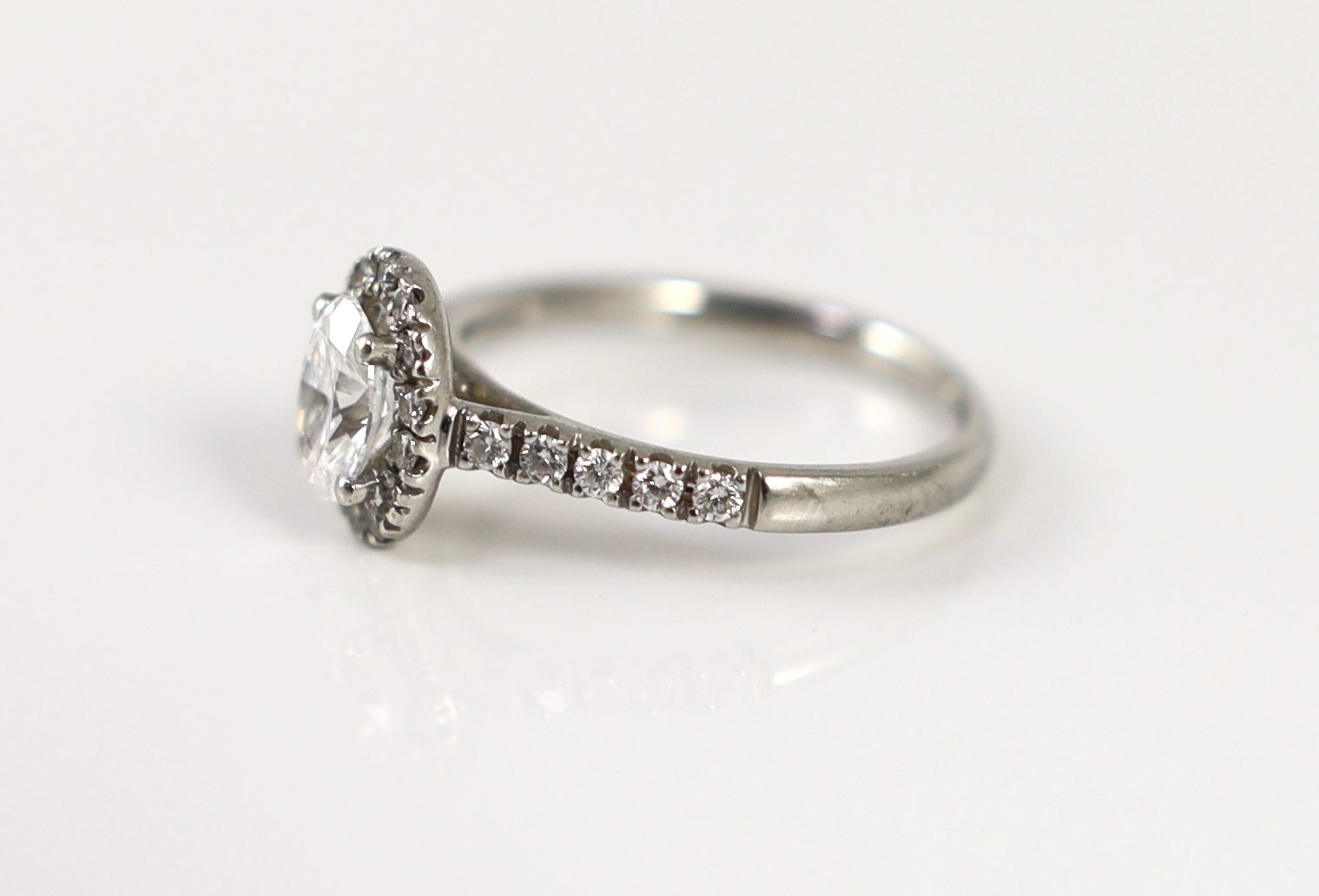 A modern platinum and single stone oval cut diamond set ring, with diamond setting and diamond set shoulders, with accompanying GIA report dated 13/8/2019, stating that the oval brilliant cut diamond to weigh 0.70ct with